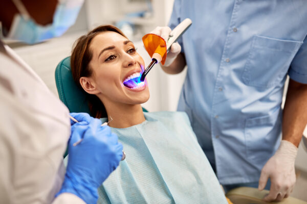 Frau beim Zahnarzt, Behandlung mit Lasertechnik
