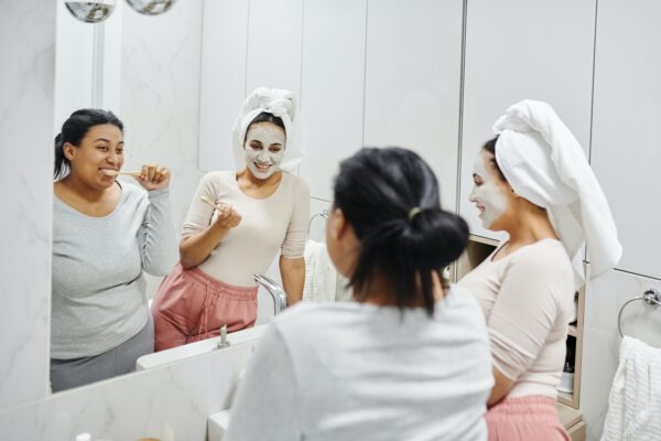 Zwei Frauen im Spiegel beim Zähneputzen
